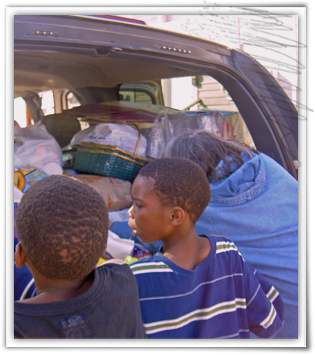 Kinship Circle volunteer Marni Reeder unloads animal supplies for residents in Upper 9th Ward West, New Orleans 315x355